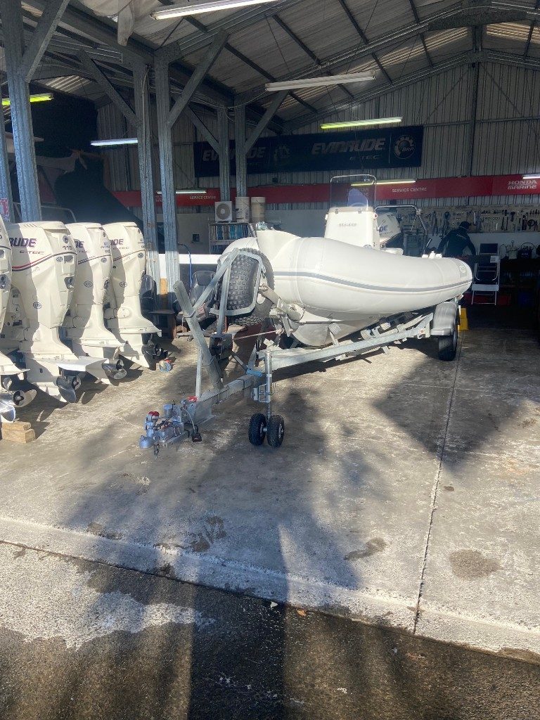 Workshop with RIB on trailer and Evinrude E-TEC outboards