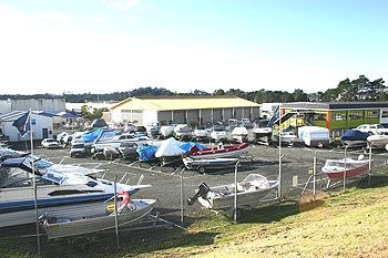 Boat storage yard at Holiday Outboards with numerous boats on trailers