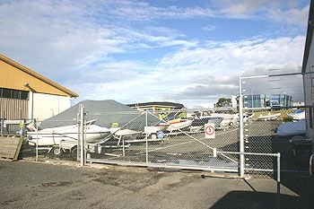Boat storage facility with rows of boats on trailers behind chain-link fence